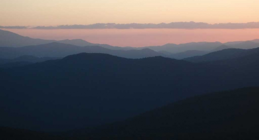 The sky appears in shades of pink above the blue ridge mountains 